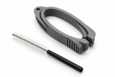 A gray plastic Signia Click Dome Removal Tool set featuring an oval handle and a small cleaning brush with a black handle.